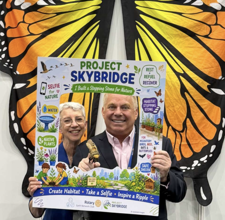 Steve Bender with the Project SkyBridge selfie frame in front of monarch butterfly wings